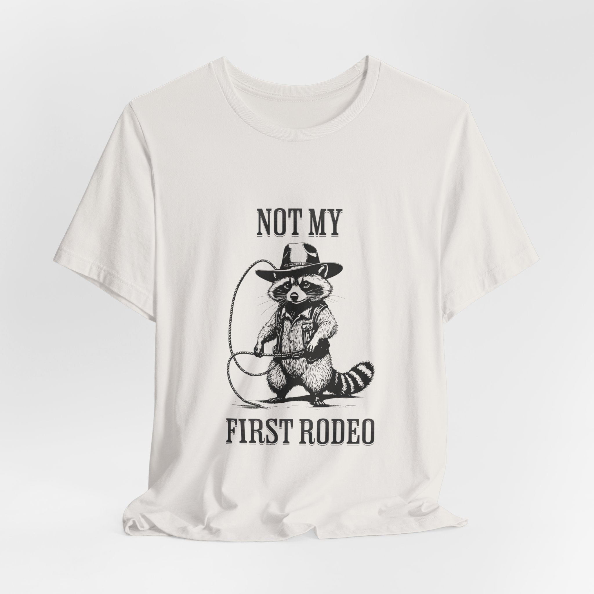 Funny Western Graphic Cotton Tee - Not My First Rodeo Cowboy Raccoon Shirt | Cute Quirky Country Style T-Shirt for Rodeo Fans & Animal Lovers | Perfect for Rodeo Events, Country Concerts & Casual Wear