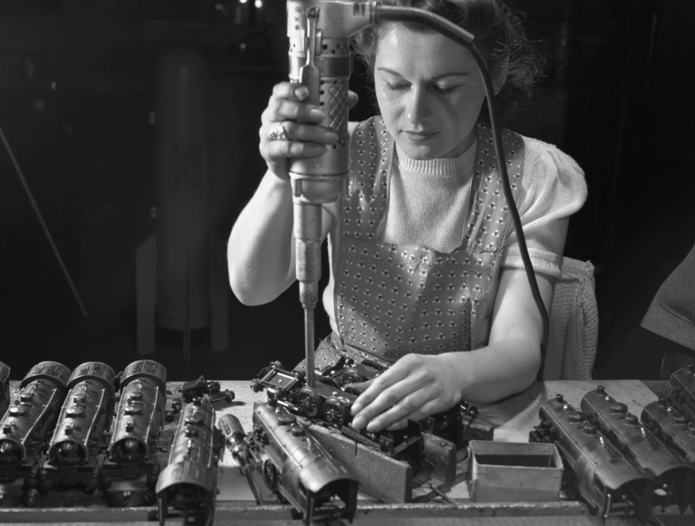 Toy Factory Worker Assembling Locomotives with Electric Screwdriver - Industrial Toy Making Scene