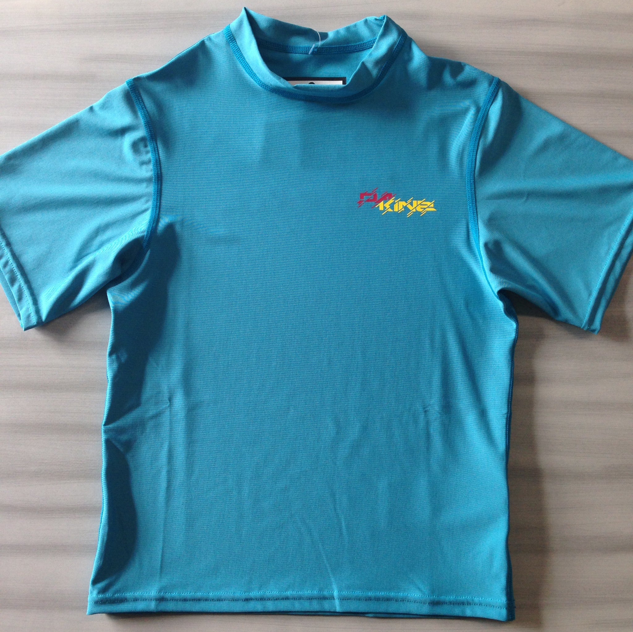 Dakine Youth Rash Guard Shirts for Kids - Heavy Duty Short Sleeve UV Protection Swim Shirt (Loose Fit, Neon Blue) - Perfect for Swimming, Surfing, and Beach Activities