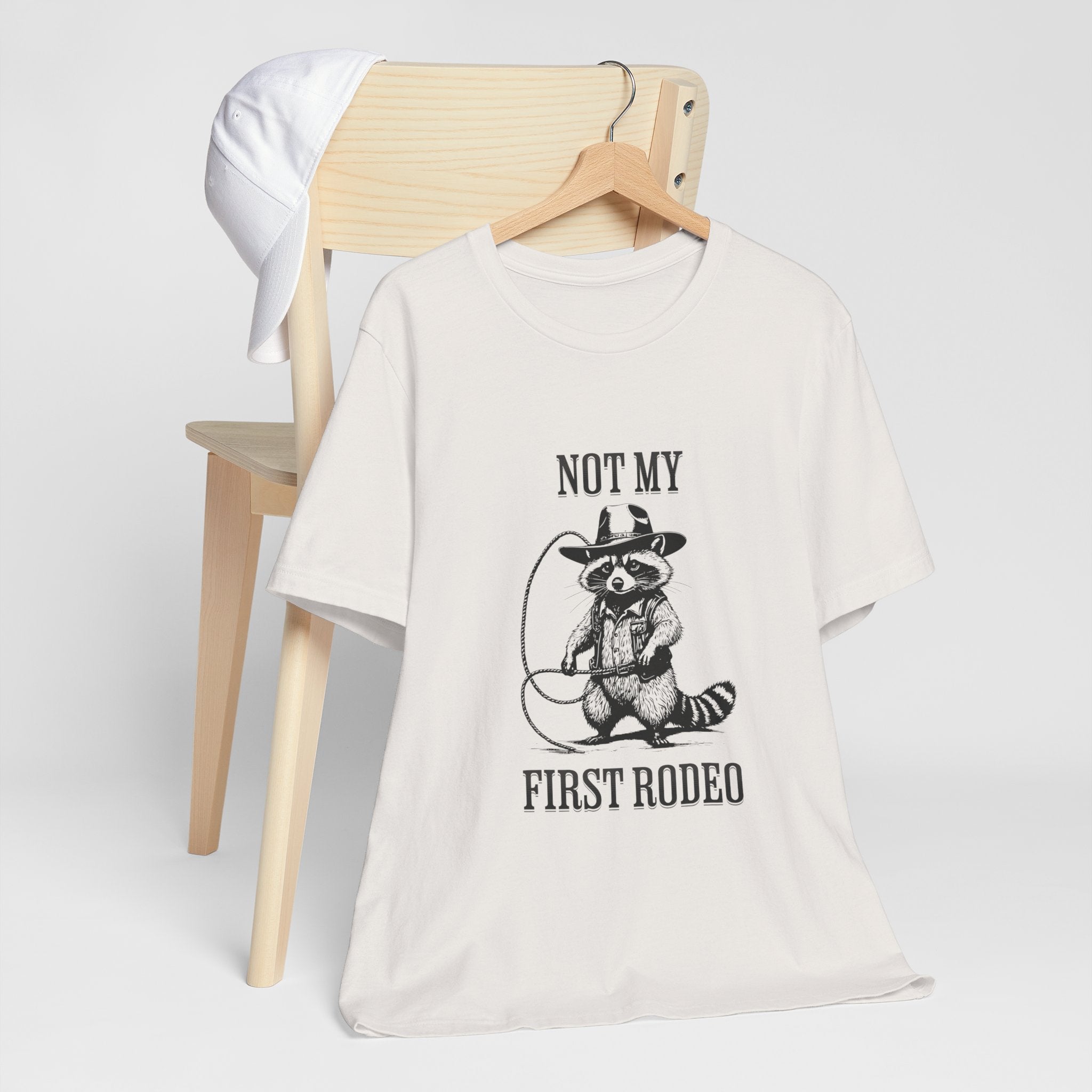 Funny Western Graphic Cotton Tee - Not My First Rodeo Cowboy Raccoon Shirt | Cute Quirky Country Style T-Shirt for Rodeo Fans & Animal Lovers | Perfect for Rodeo Events, Country Concerts & Casual Wear