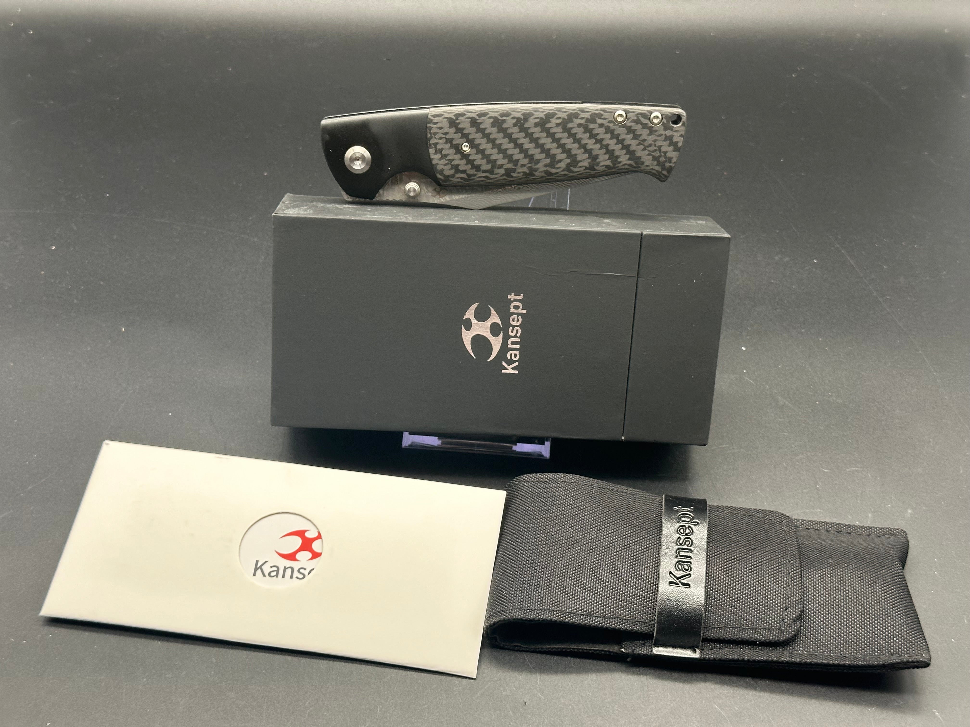 KANSEPT SHIKARI Folding Knife - Black Titanium Handle with Twill Carbon Fiber Inlay & Damascus Steel Blade - Plain Edge for Outdoor, Camping, and EDC Use