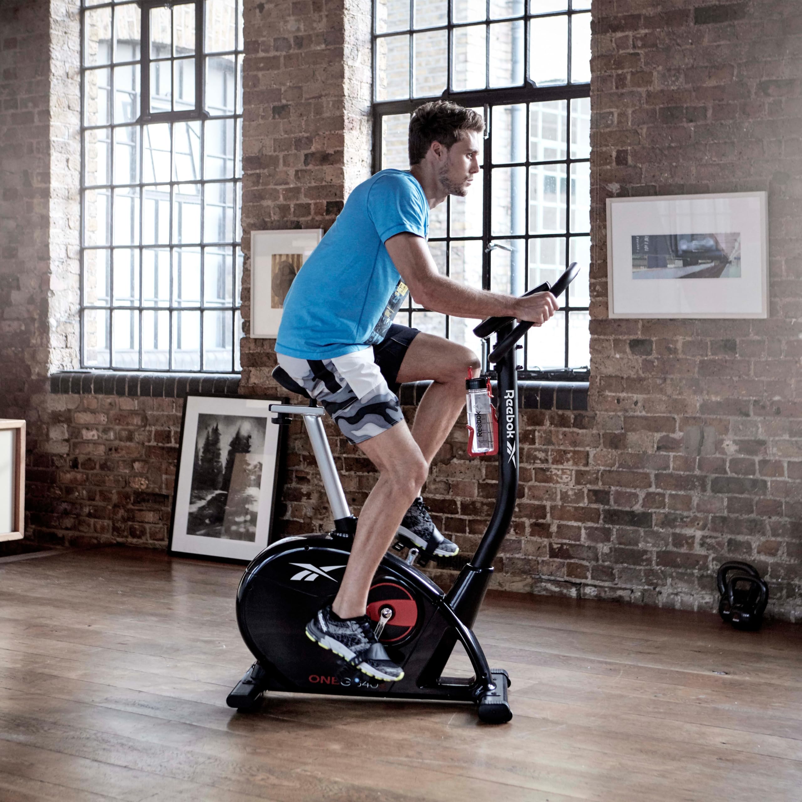 Reebok Fitness Stationary Bike - Bluetooth Indoor Cycling Bike with 24 Resistance Levels & 12 Workout Programs | Upright Exercise Bike with Gel Pad Saddle for Home Gym, Cardio Training & Weight Loss