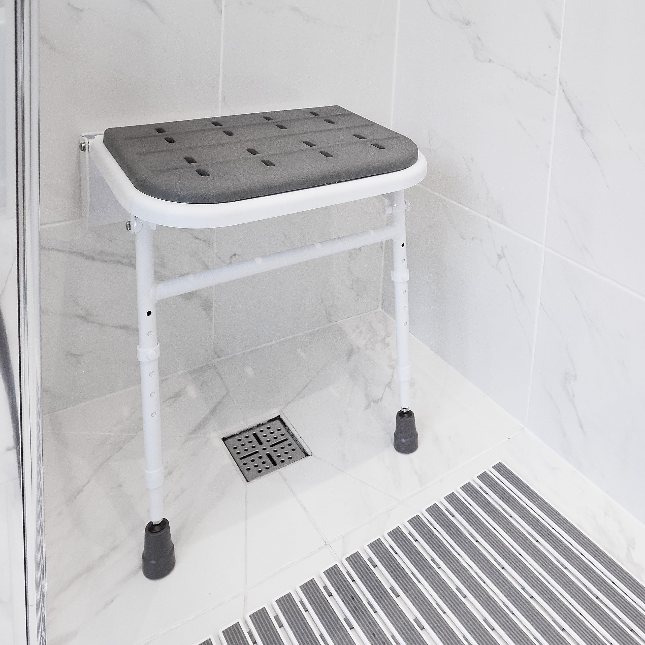 NRS Healthcare Wall Mounted Folding Shower Seat with Padded Seat & Adjustable Legs - Safe Bathroom Shower Chair for Elderly & Disabled - Ideal for Small Spaces & Home Care Use
