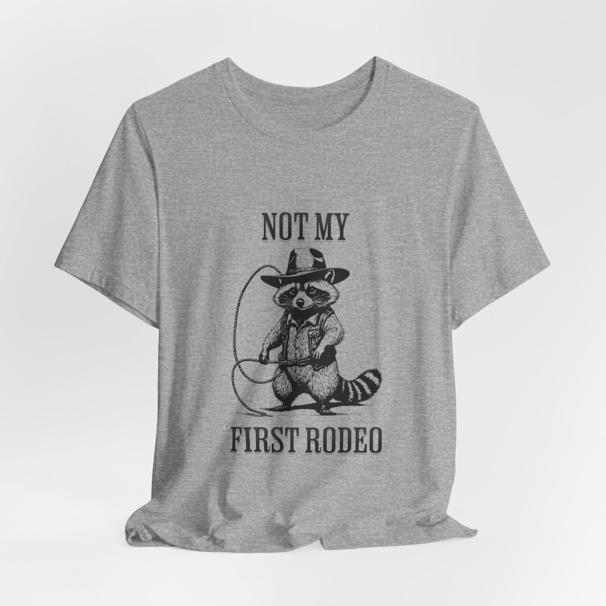 Funny Western Graphic Cotton Tee - Not My First Rodeo Cowboy Raccoon Shirt | Cute Quirky Country Style T-Shirt for Rodeo Fans & Animal Lovers | Perfect for Rodeo Events, Country Concerts & Casual Wear