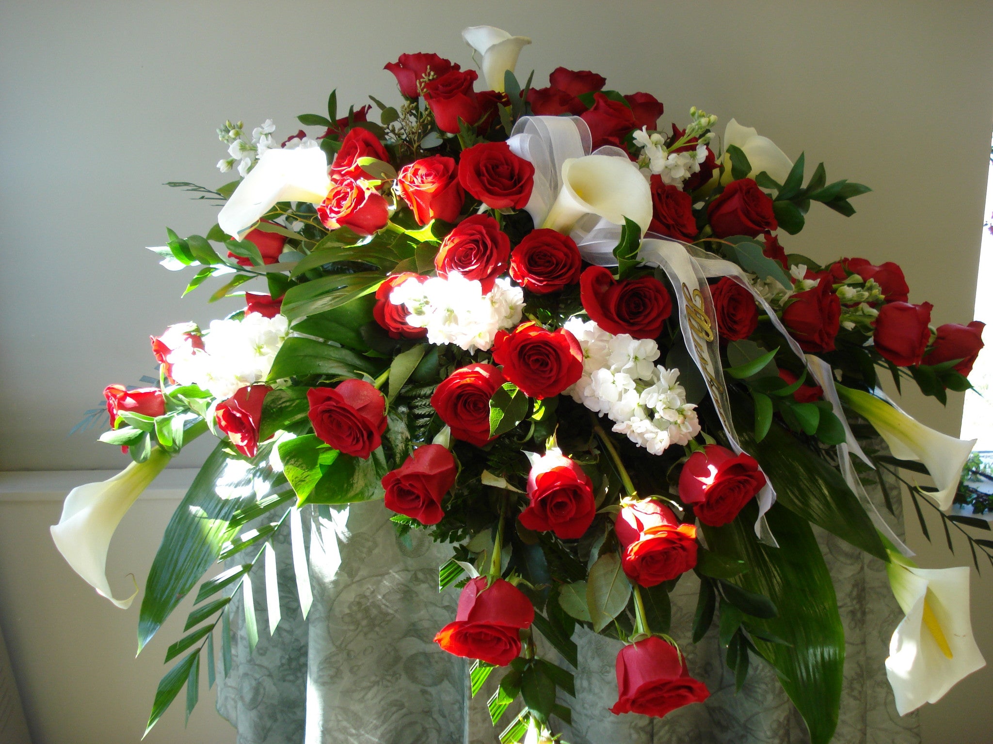 Elegant Red Roses and Calla Lilies Casket Spray for Funeral Memorials - Perfect for Sympathy Arrangements and Graveside Tributes