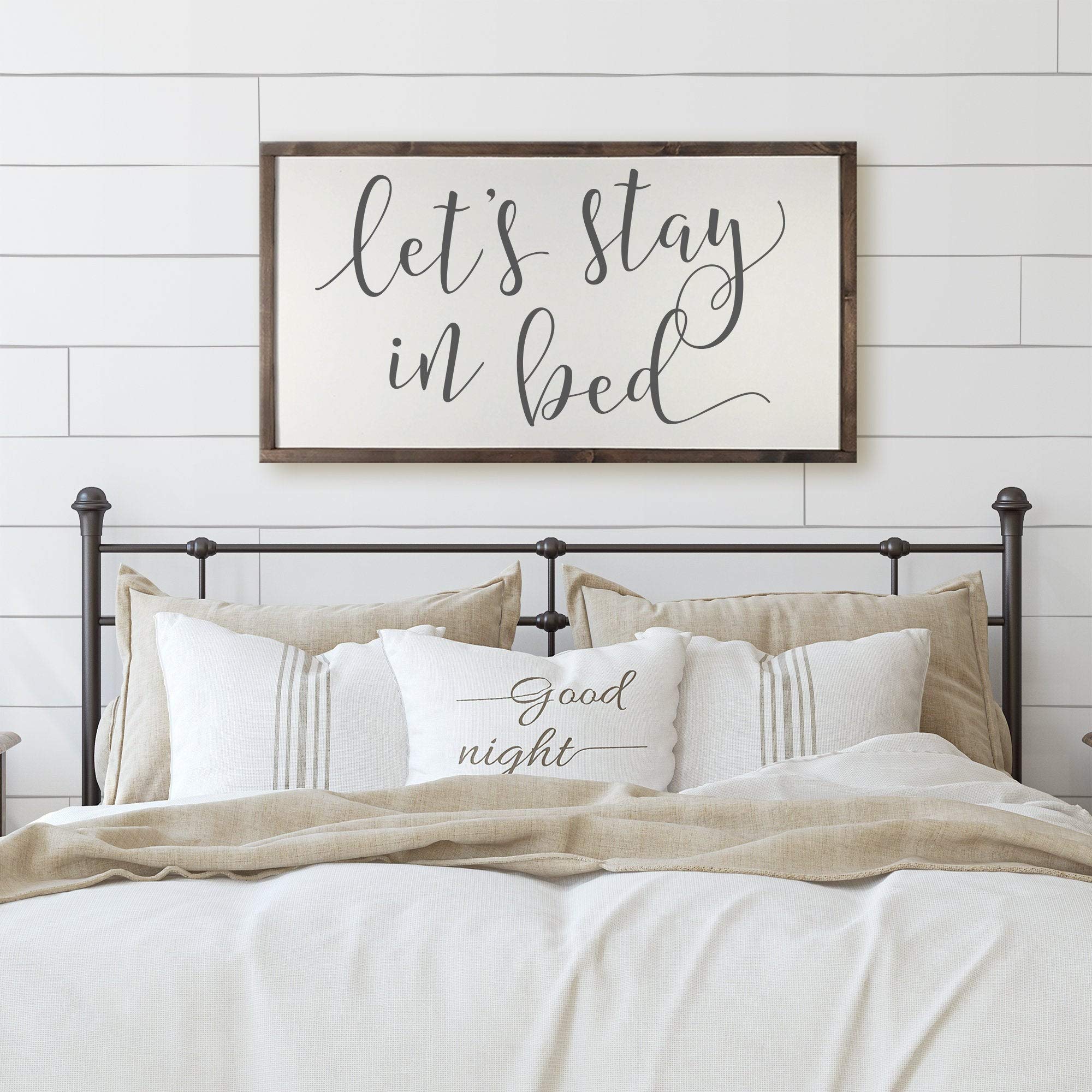 Farmhouse Wooden Wall Sign - 'Let's Stay in Bed' Framed Bedroom Decor 12x22 Inch - Rustic Home Art for Cozy Bedrooms & Relaxing Spaces