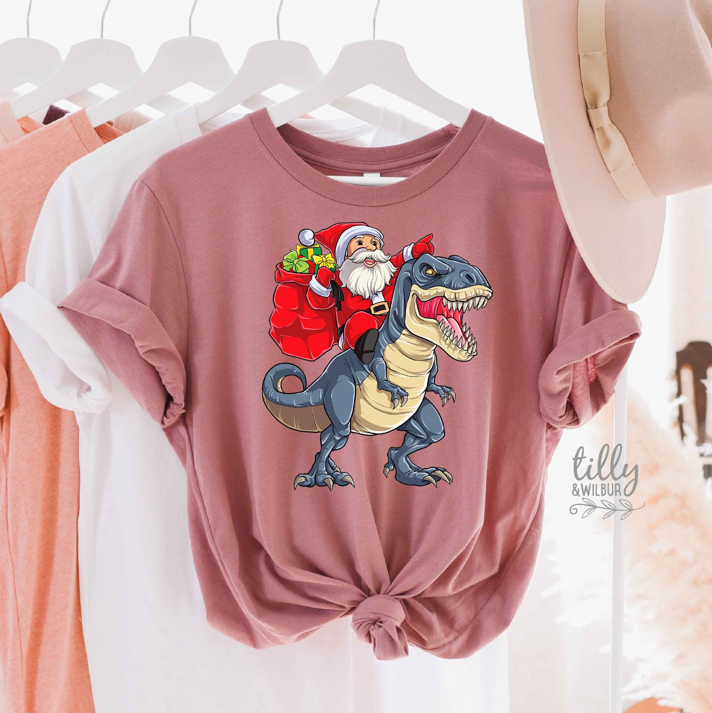 Santa Riding Dinosaur Christmas T-Shirt - Festive Holiday Graphic Tee for Men & Women - Multiple Colors Available - Perfect for Xmas Parties & Gifts