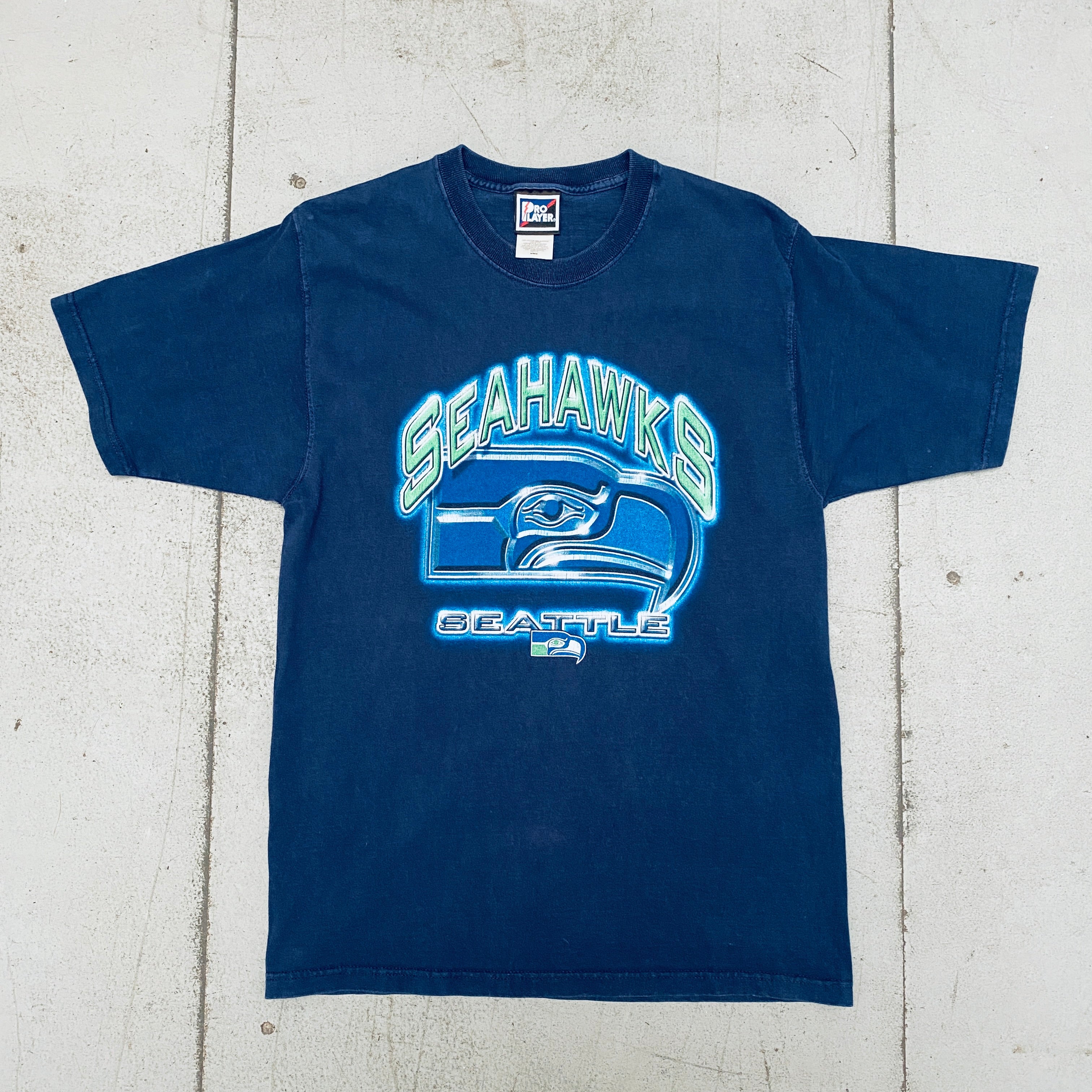 Seattle Seahawks 1990s Pro Player Graphic Spellout T-Shirt for Men & Women - Vintage NFL Football Fan Apparel (Sizes S/M) - Perfect for Game Day, Tailgating & Casual Wear