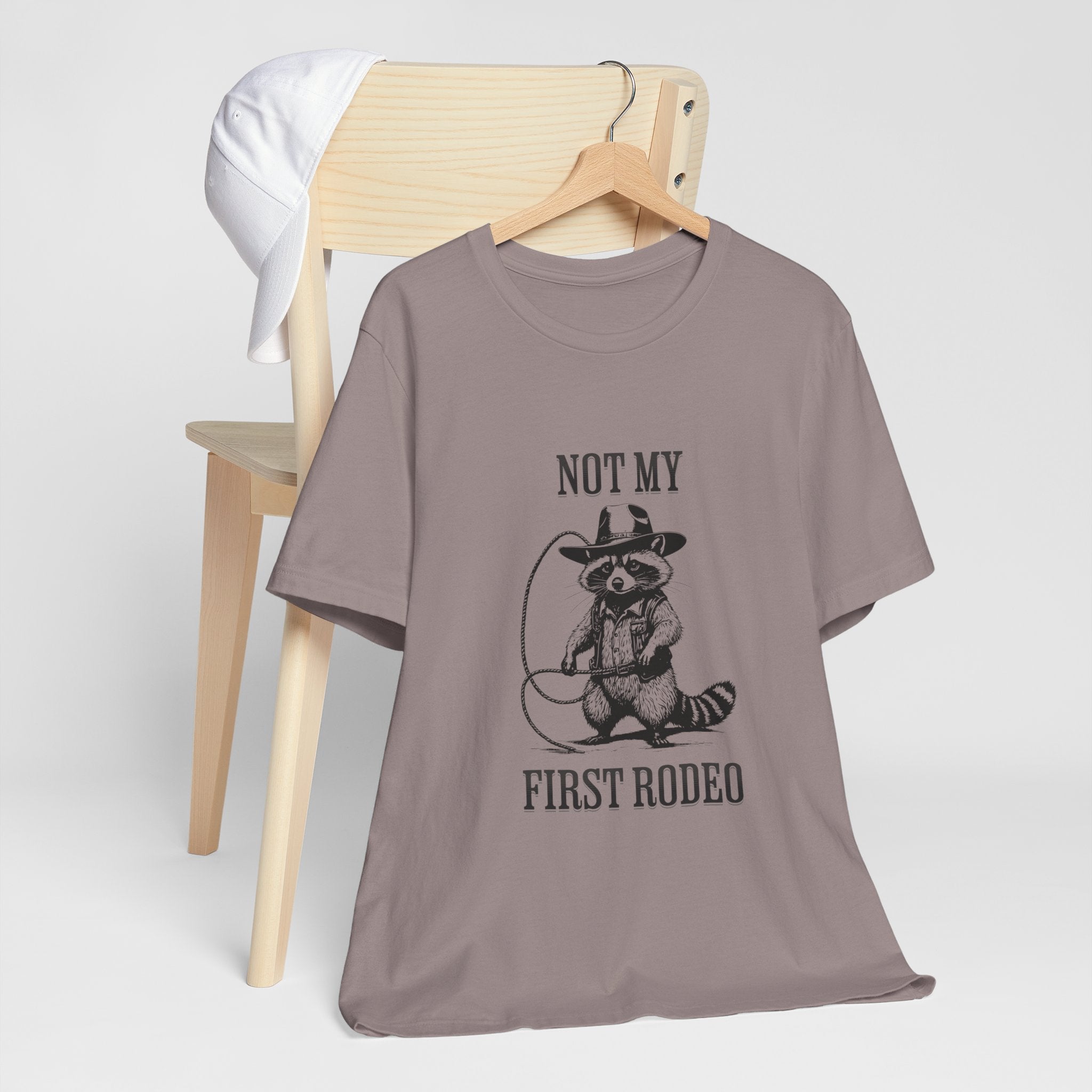Funny Western Graphic Cotton Tee - Not My First Rodeo Cowboy Raccoon Shirt | Cute Quirky Country Style T-Shirt for Rodeo Fans & Animal Lovers | Perfect for Rodeo Events, Country Concerts & Casual Wear