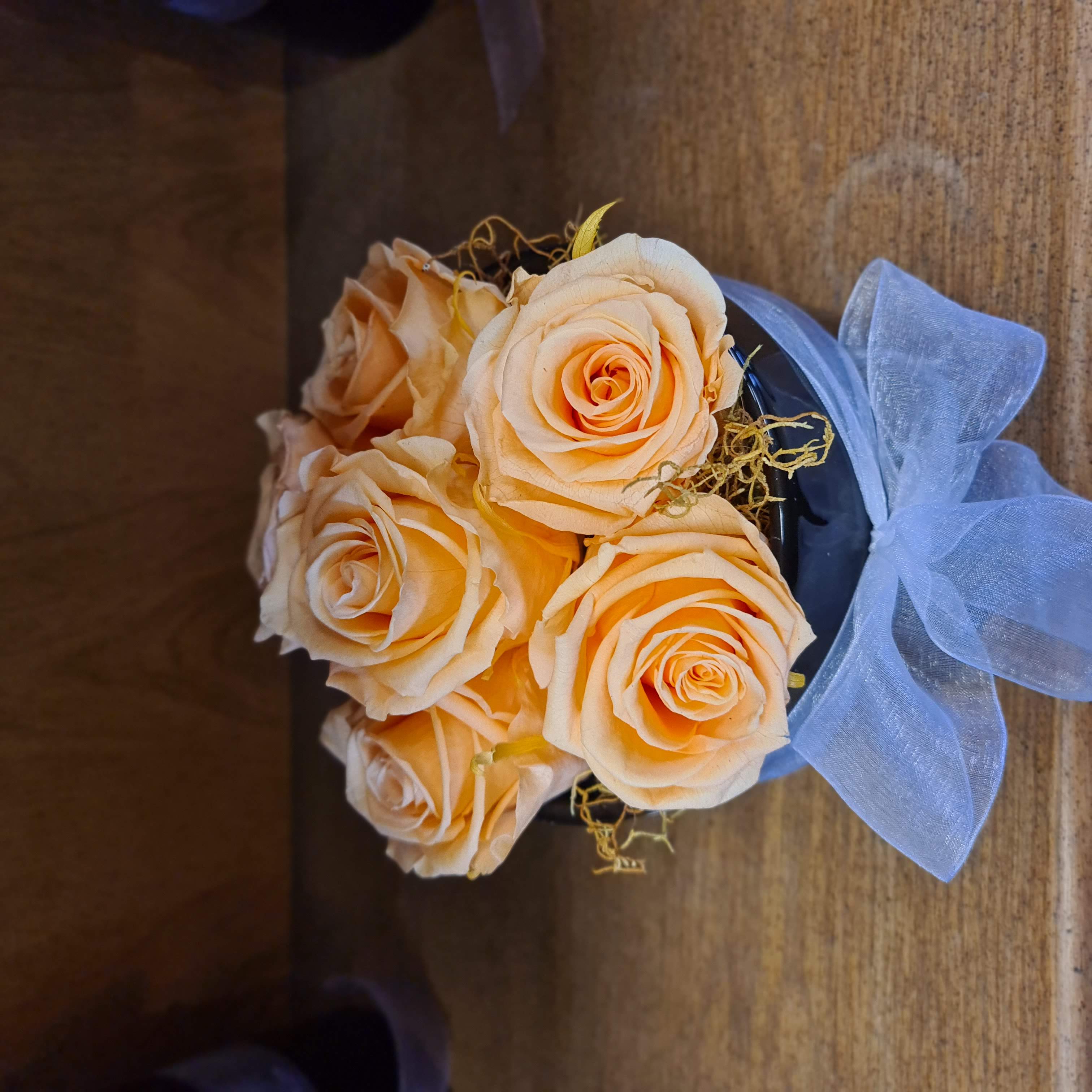 Peach preserved roses in black ceramic vase
