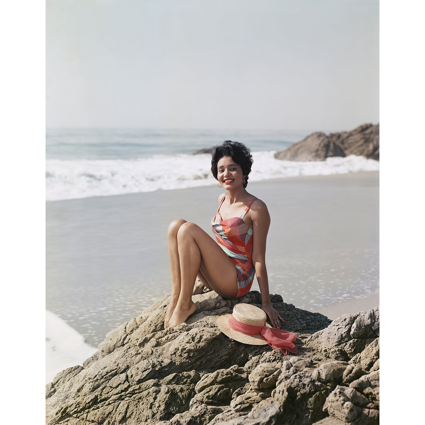 Beautiful Young Woman Sitting by the Ocean - High Quality Stock Photo from Getty Images | Perfect for Travel Blogs, Beach-Themed Websites, and Summer Marketing Campaigns