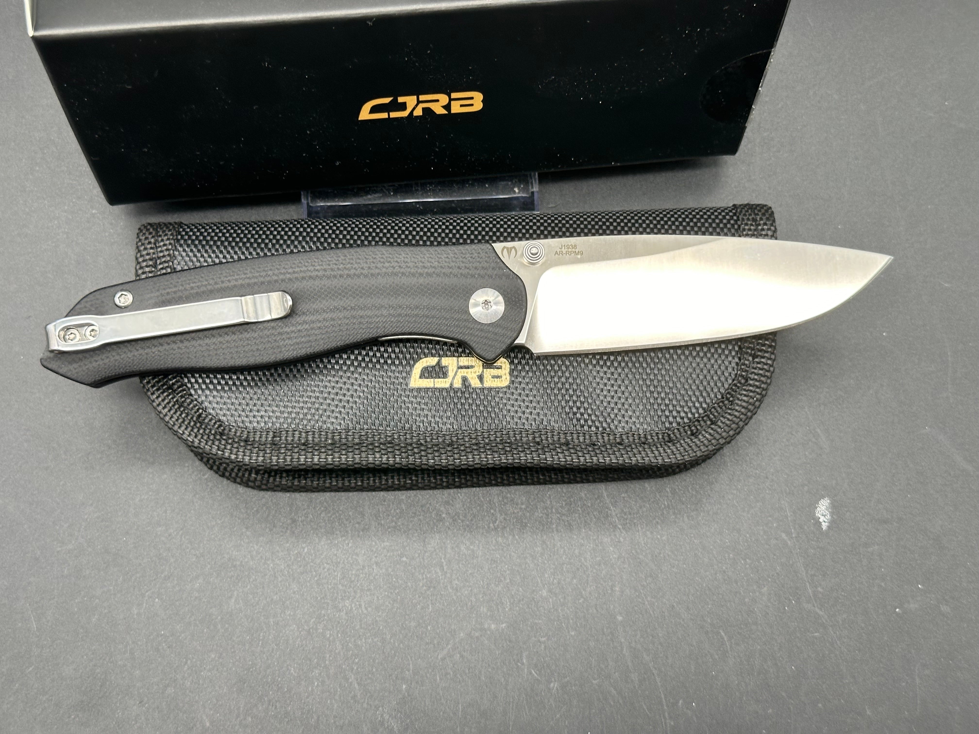 CJRB AES Folding Knife - Black G10 & Brass Handle, AR-RPM9 Steel, Drop Point Plain Edge, Sand Polish Finish - EDC, Camping, Outdoor Survival