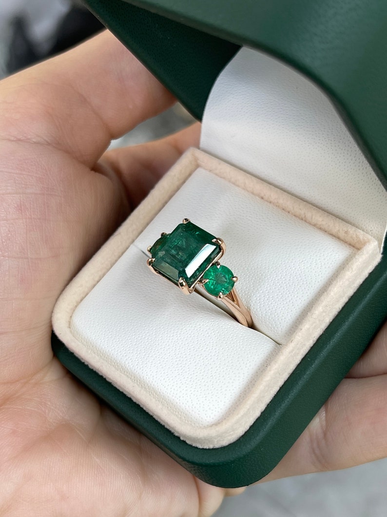 6.98 TCW Dark Green Emerald Cut & Round Trilogy Three Stone Engagement Ring in 14K Rose Gold - Perfect for Proposals, Anniversaries, and Special Occasions